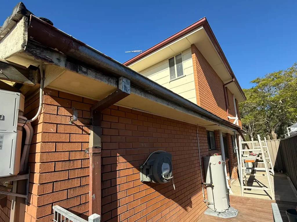 Rusted gutter and deteriorated timber fascia before replacement in Bossley Park